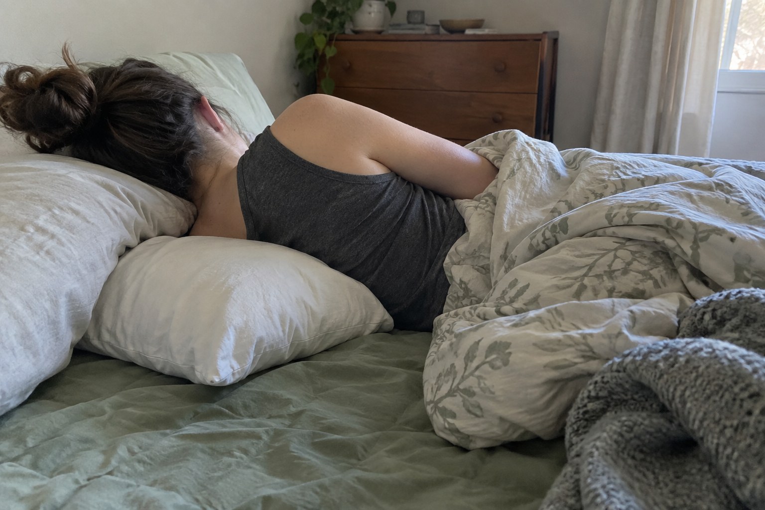 Side sleeper rests with a pillow supporting the upper arm.