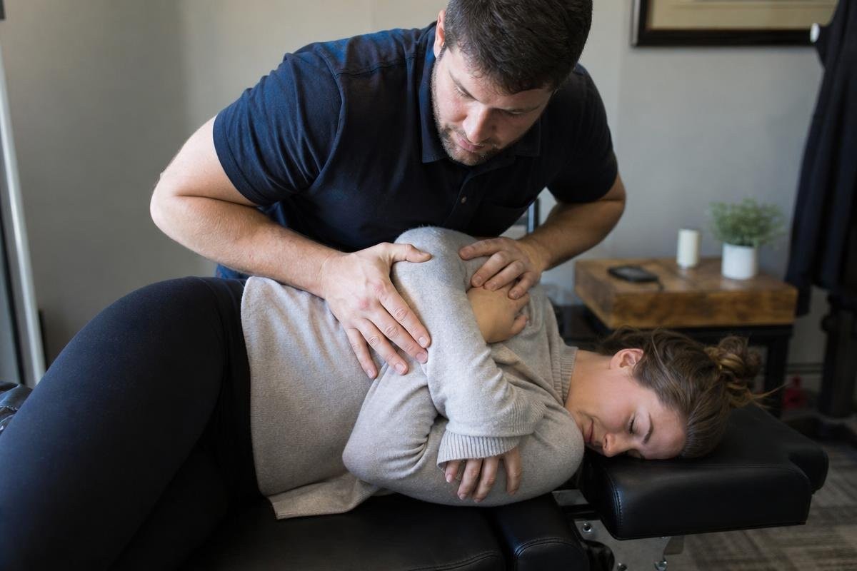 Chiropractor performing a side-lying spinal adjustment on a patient in Alexandria, VA